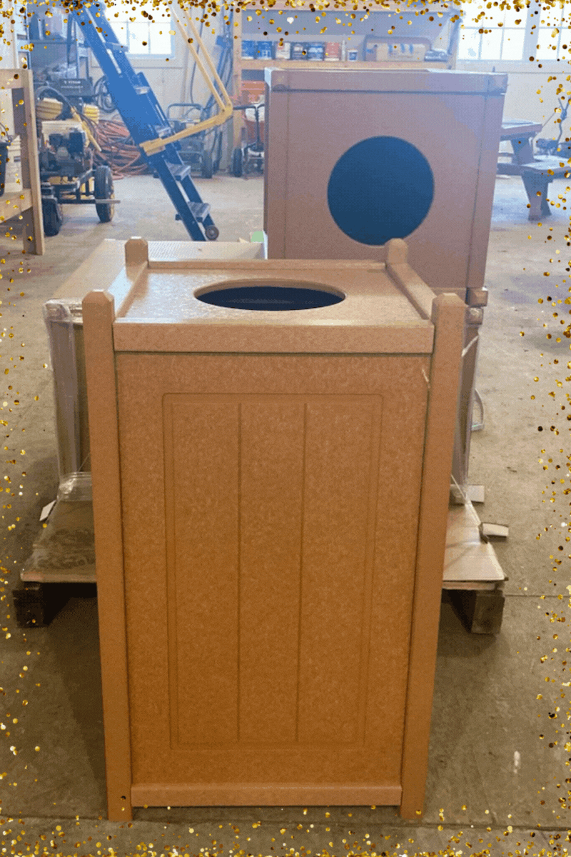 Municipal-style, light tan trashcans sit half-opened on a pallet in a workshop while a shooting star animation plays overlayed on the image.