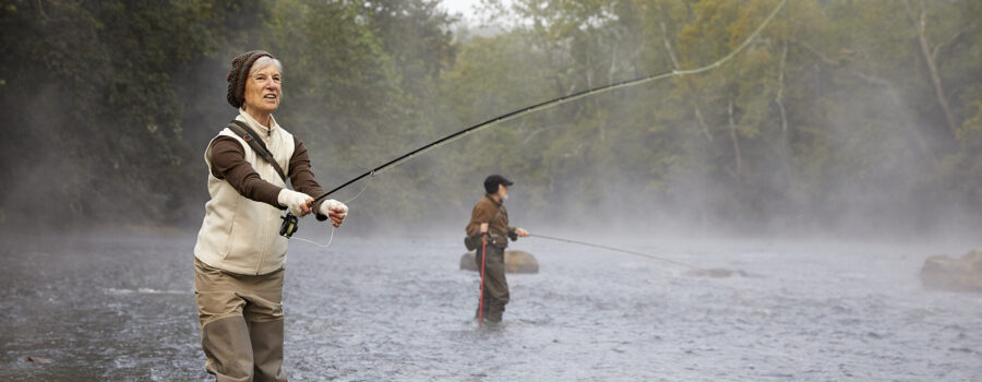 A Valley Treasure Award seal overlay a photo of a woman standing in what looks like a cold misty river casting a fly reel.